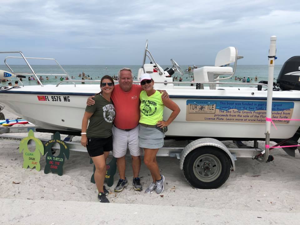 Volunteers front of a boat.